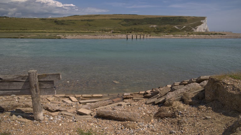A high tide nears the top of the river Cuckmere bank